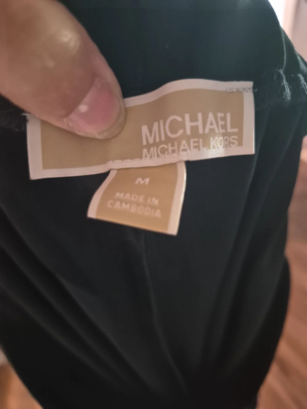Michael Kors black wide-leg trousers featuring prominent front patch pockets